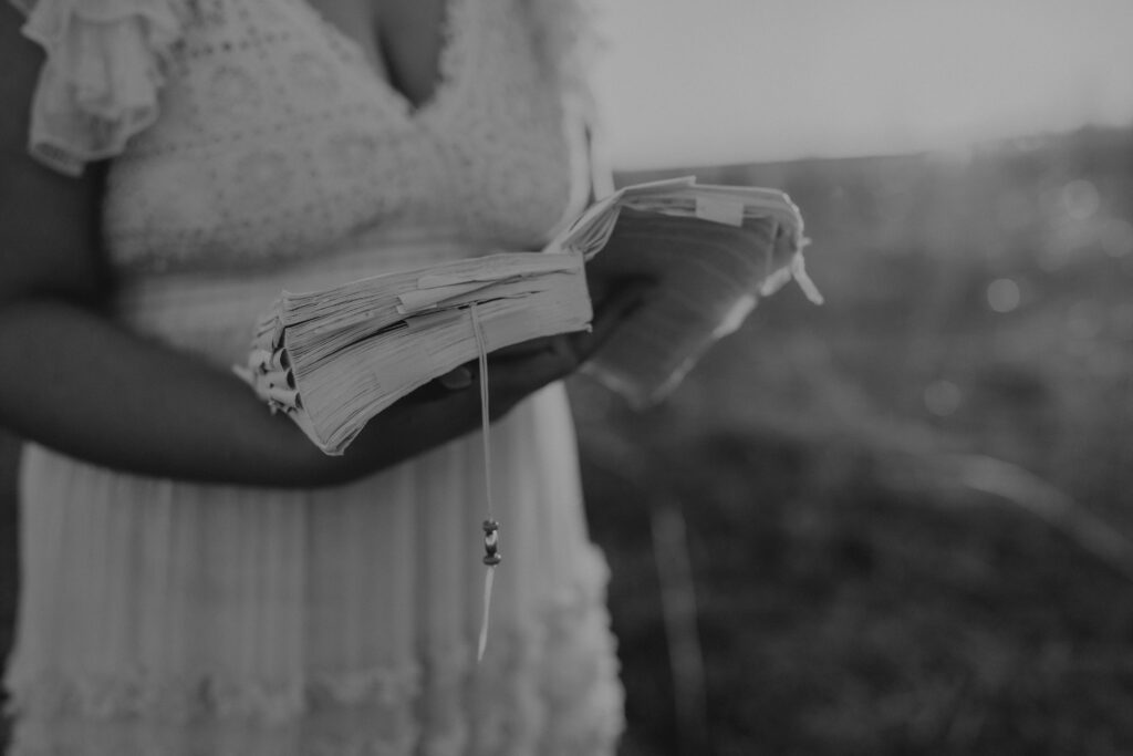 Emilee Rachelle holding a bible in a field.